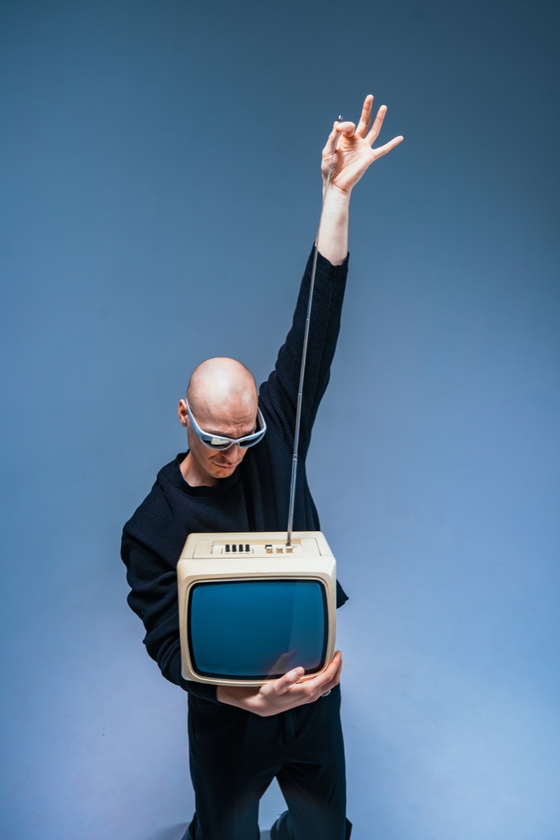 Palmowski trzymający retro telewizor kineskopowy